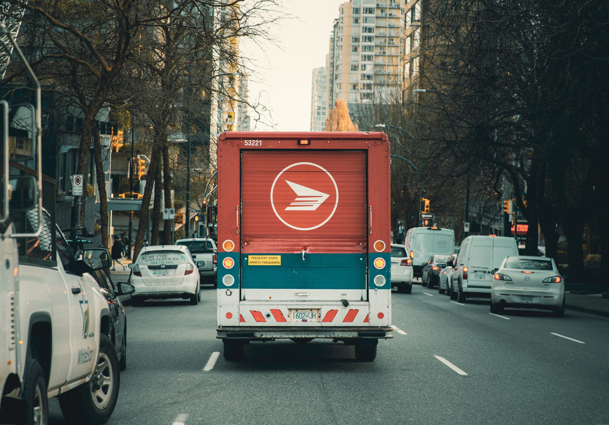 A Canada Post trunk drives down a busy Toronto street