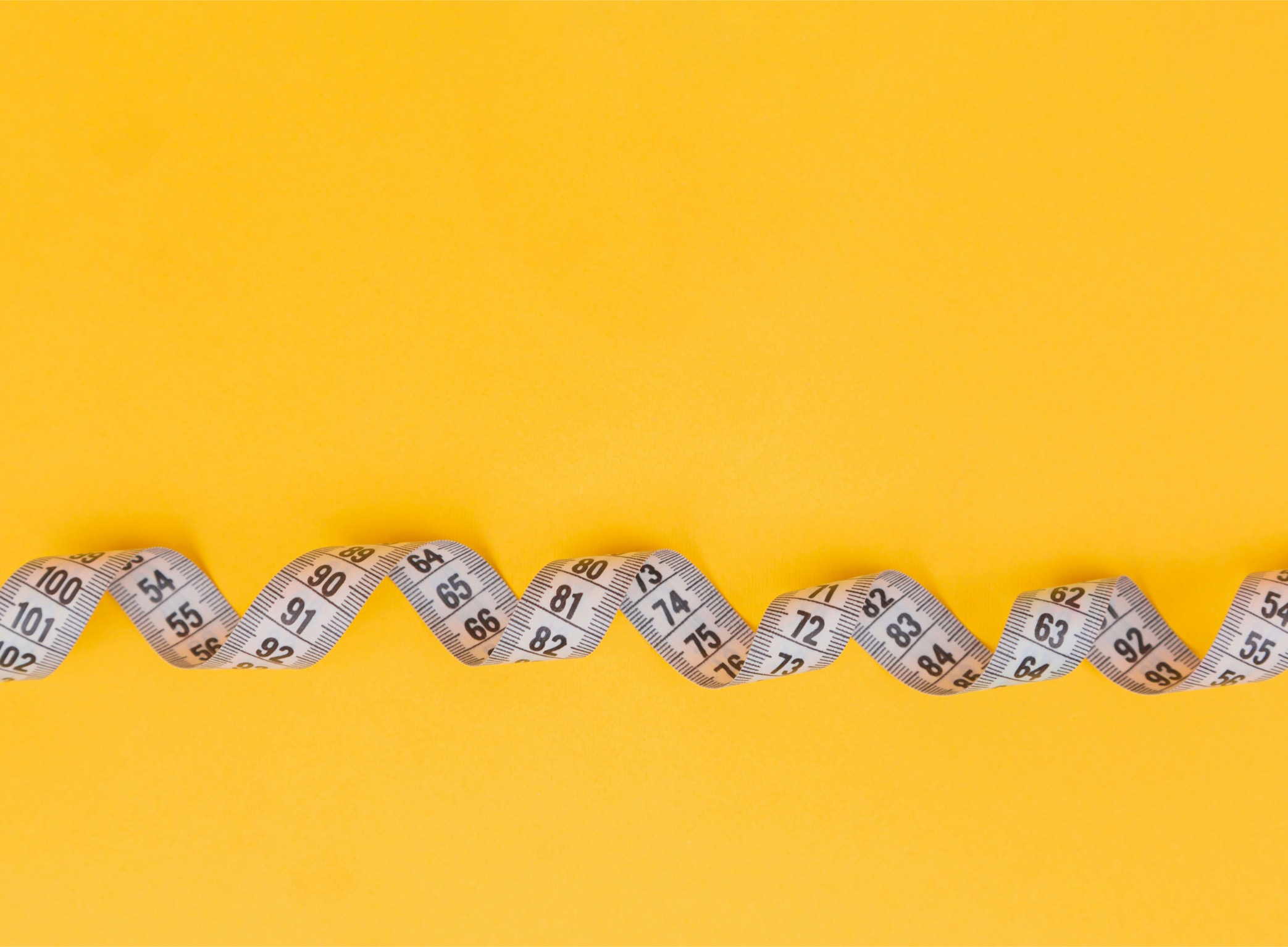 Measuring tape on yellow background representing how to measure cause marketing success and track event metrics