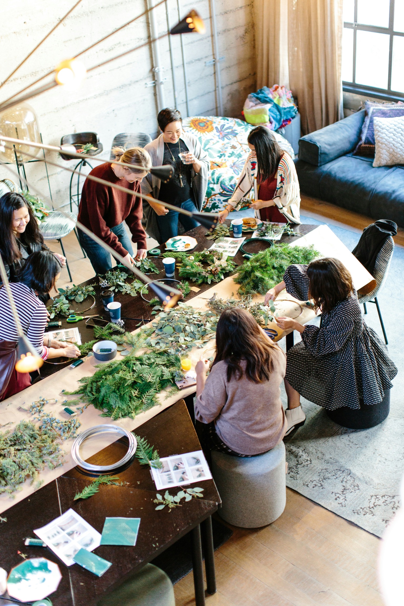Group of women making holiday wreaths together at a cause marketing workshop event, creating hands-on engagement for environmental charity