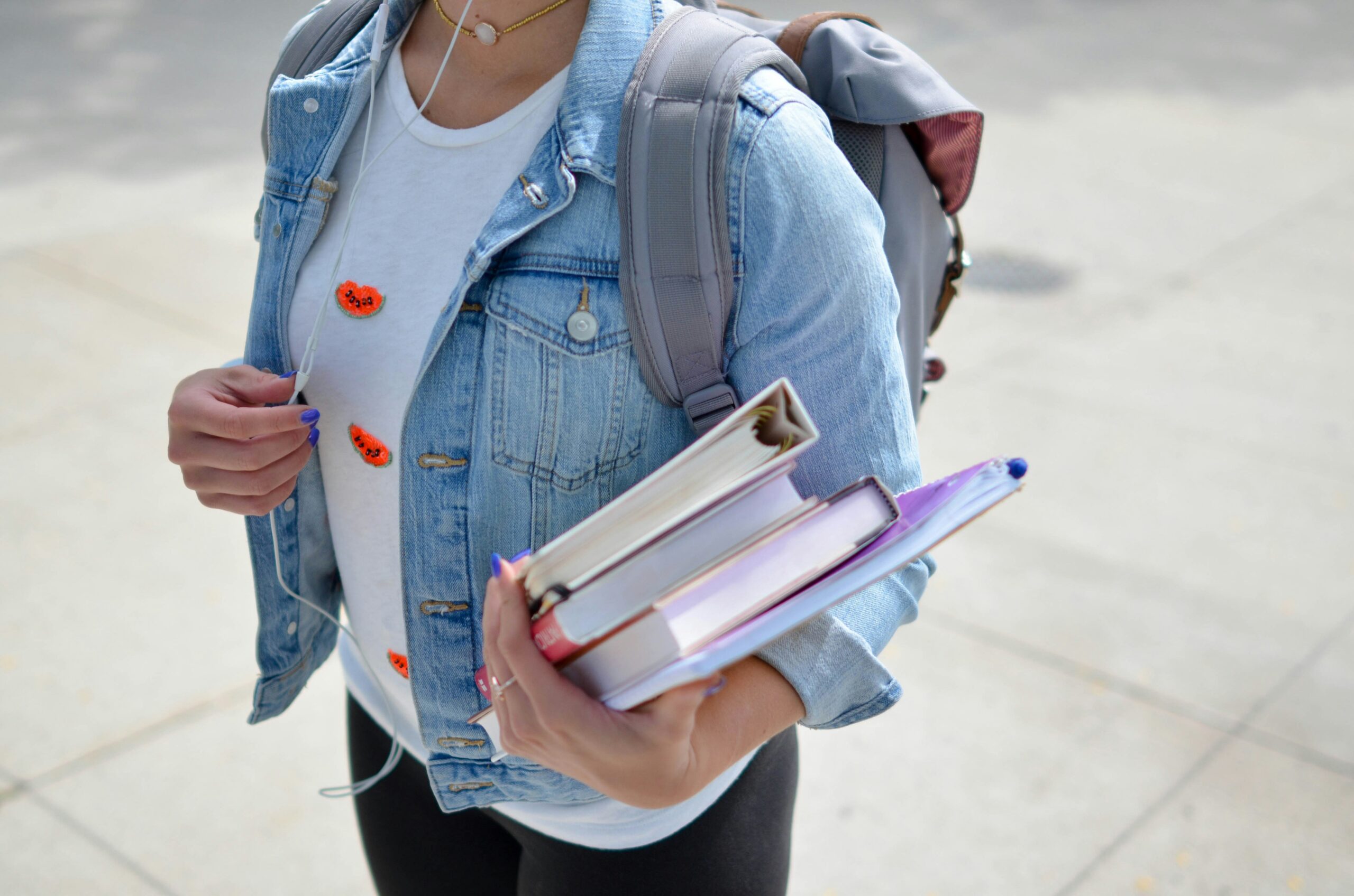 back-to-school-student-books-backpack Student carrying textbooks and wearing a backpack, ready for the new school year